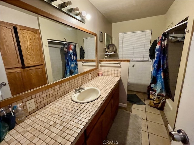 bathroom featuring tile patterned floors, vanity, shower / bath combination with curtain, and backsplash