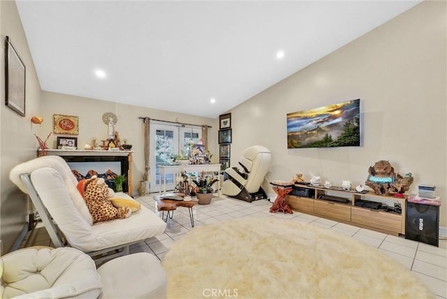 sitting room with french doors, light tile patterned floors, and lofted ceiling