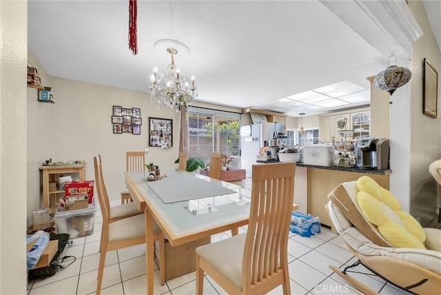 dining space with light tile patterned floors and an inviting chandelier