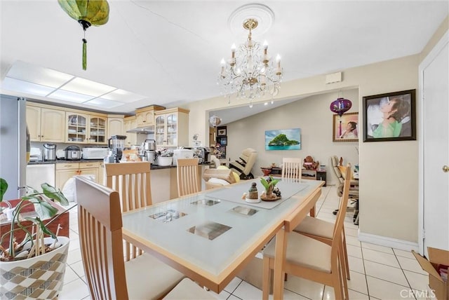 dining area featuring a notable chandelier, light tile patterned floors, and vaulted ceiling