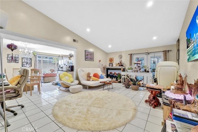 tiled living room featuring a notable chandelier, a healthy amount of sunlight, and lofted ceiling