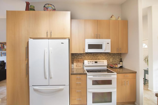 kitchen featuring light brown cabinets, backsplash, dark stone countertops, and white appliances