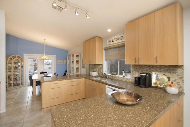 kitchen featuring lofted ceiling, kitchen peninsula, decorative backsplash, sink, and light brown cabinets