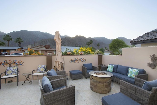 view of patio / terrace featuring an outdoor living space with a fire pit and a mountain view