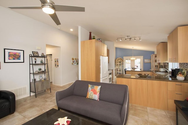 living room with lofted ceiling, light tile patterned floors, ceiling fan, and sink