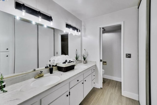 bathroom with hardwood / wood-style floors, vanity, and toilet