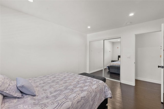 bedroom with dark hardwood / wood-style flooring and a closet