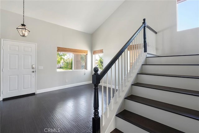 foyer featuring dark hardwood / wood-style floors and vaulted ceiling