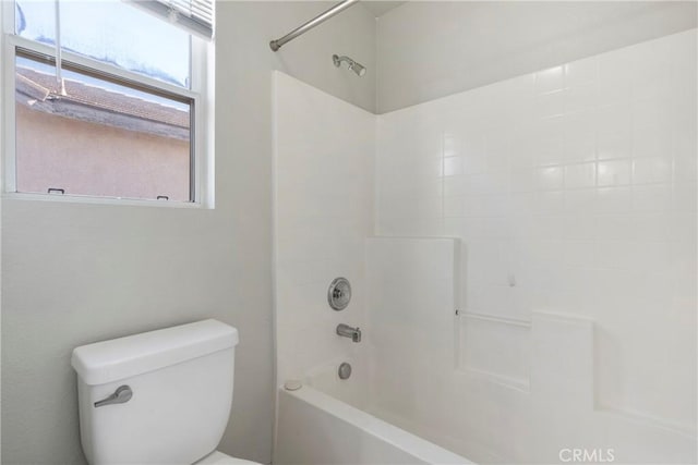 bathroom featuring toilet and tiled shower / bath