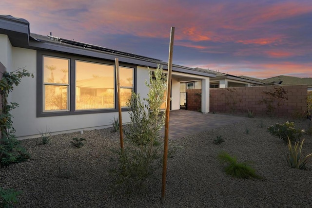 property exterior at dusk with a patio area