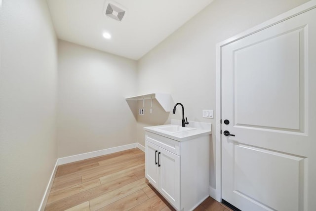 laundry room featuring light hardwood / wood-style flooring and sink