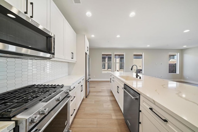 kitchen with plenty of natural light, light hardwood / wood-style floors, sink, and appliances with stainless steel finishes