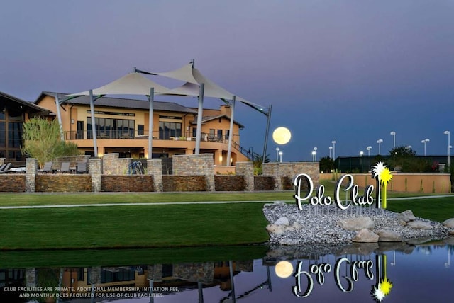 view of property's community with a water view and a lawn