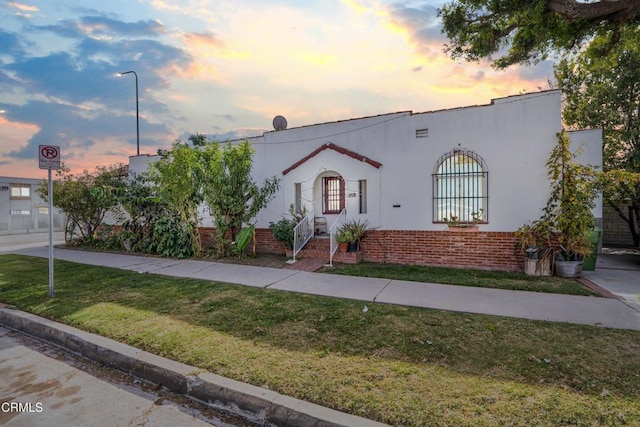 mediterranean / spanish-style house with a yard