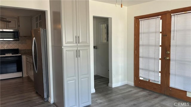 kitchen with backsplash, hardwood / wood-style flooring, french doors, and appliances with stainless steel finishes