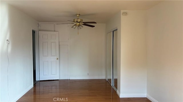 empty room with ceiling fan and dark wood-type flooring