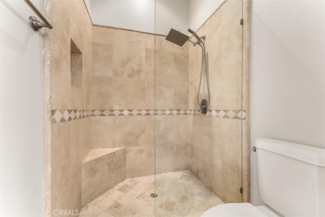 bathroom with toilet and tiled shower