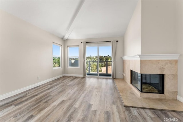 unfurnished living room with lofted ceiling, a fireplace, and light hardwood / wood-style flooring