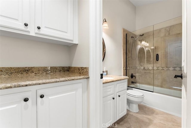 full bathroom with tile patterned flooring, vanity, enclosed tub / shower combo, and toilet