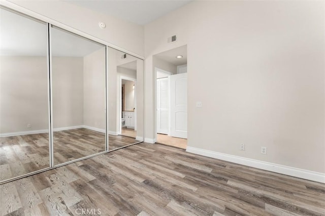 unfurnished bedroom with a closet and hardwood / wood-style flooring