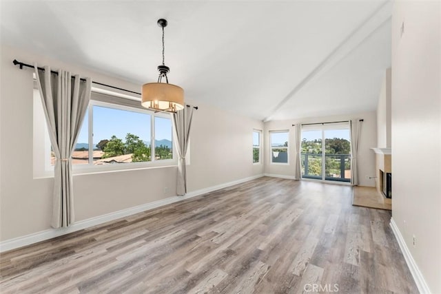 unfurnished living room with lofted ceiling and light wood-type flooring