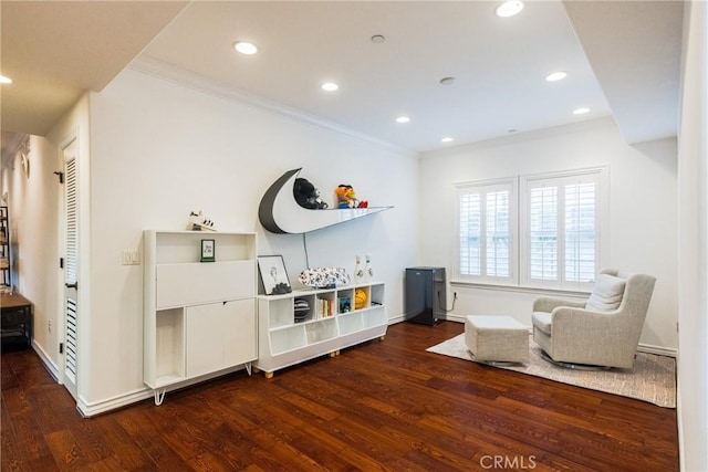 sitting room featuring ornamental molding and dark wood-type flooring