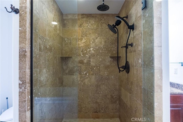 bathroom featuring toilet and a tile shower