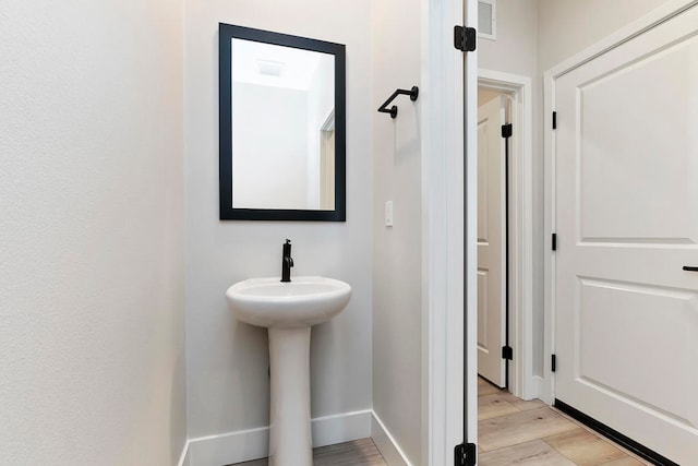 bathroom with wood-type flooring and sink