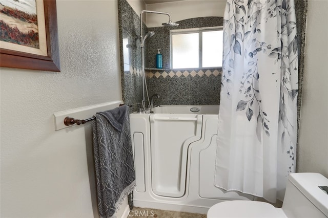 bathroom featuring shower / bath combination with curtain and toilet