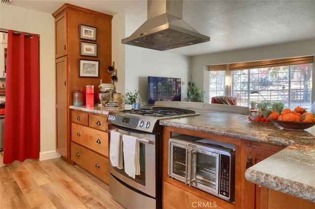 kitchen featuring island range hood, light wood-type flooring, and stainless steel appliances