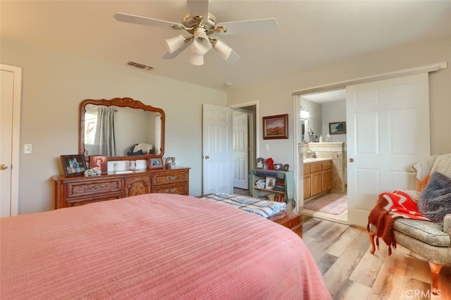 bedroom featuring ceiling fan, light wood-type flooring, and ensuite bathroom