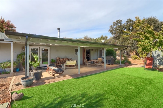 rear view of house featuring a yard and a patio