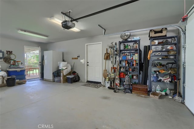 garage featuring white fridge and a garage door opener