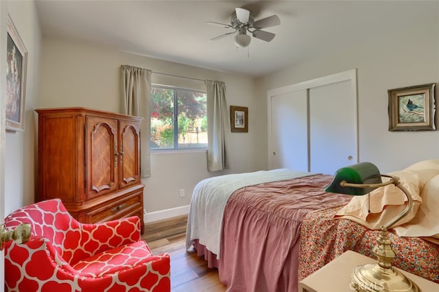 bedroom featuring ceiling fan, light hardwood / wood-style floors, and a closet