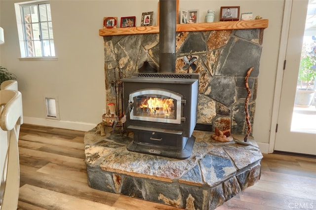 interior details with wood-type flooring and a wood stove