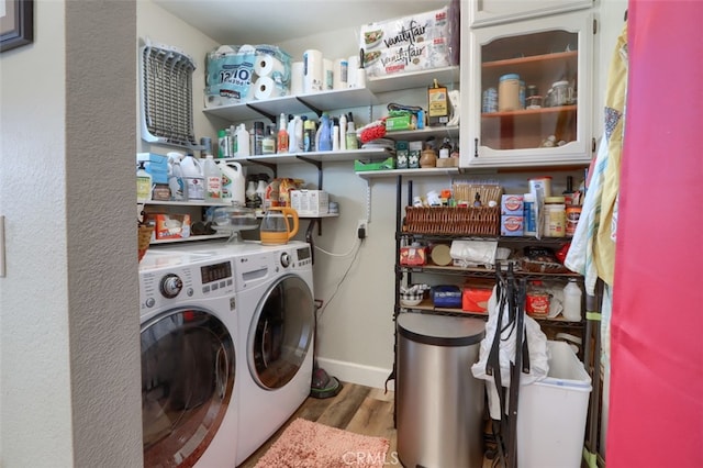 laundry area featuring independent washer and dryer and light hardwood / wood-style flooring