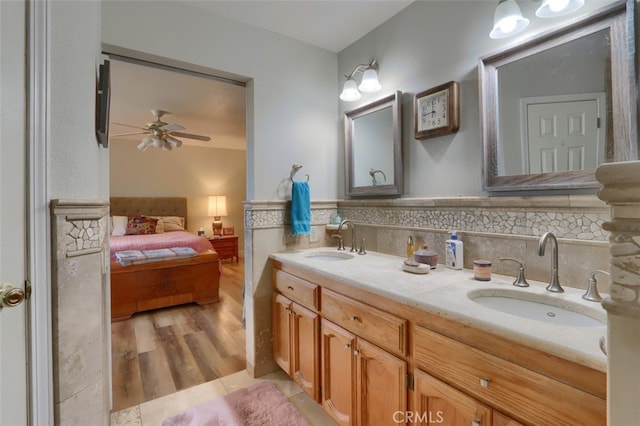 bathroom featuring tasteful backsplash, vanity, hardwood / wood-style flooring, and ceiling fan