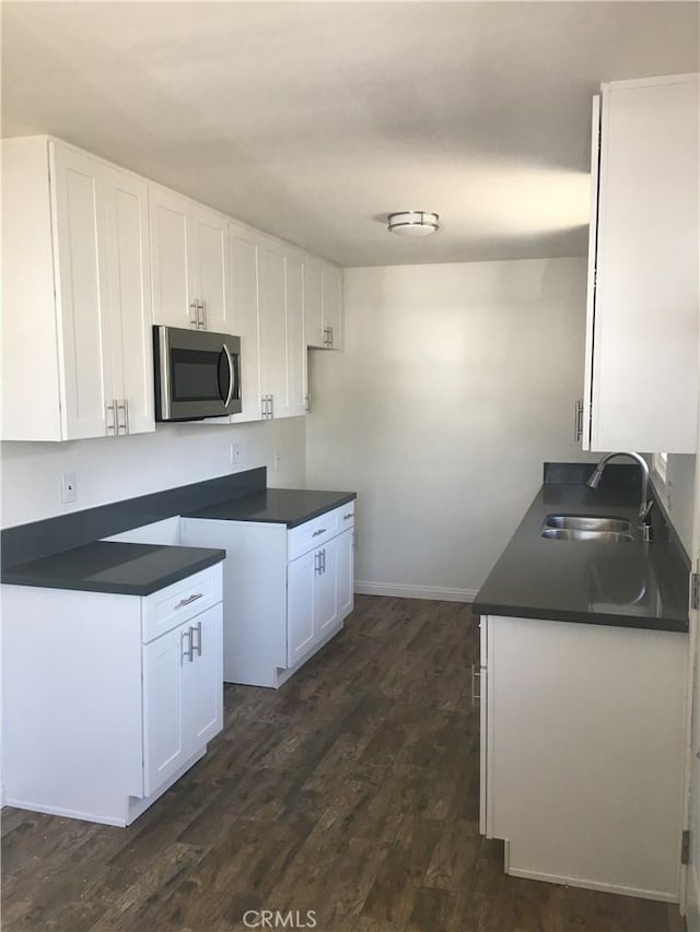 kitchen with white cabinets, sink, and dark wood-type flooring