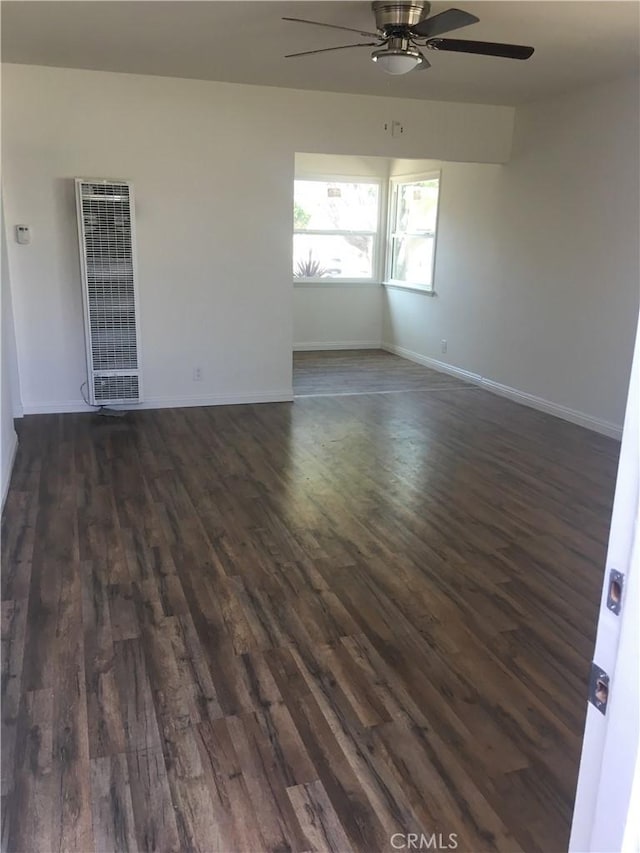 spare room with ceiling fan and dark wood-type flooring