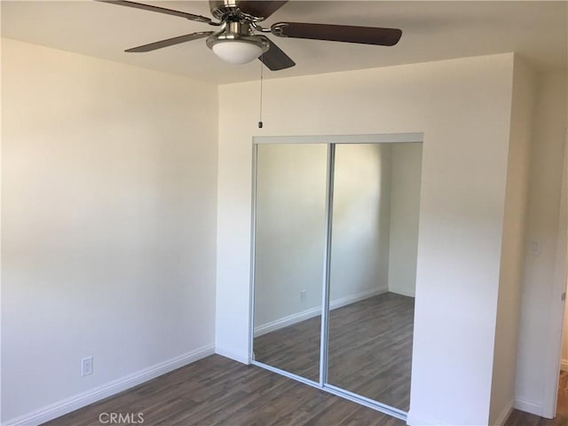 unfurnished bedroom featuring ceiling fan, dark hardwood / wood-style floors, and a closet