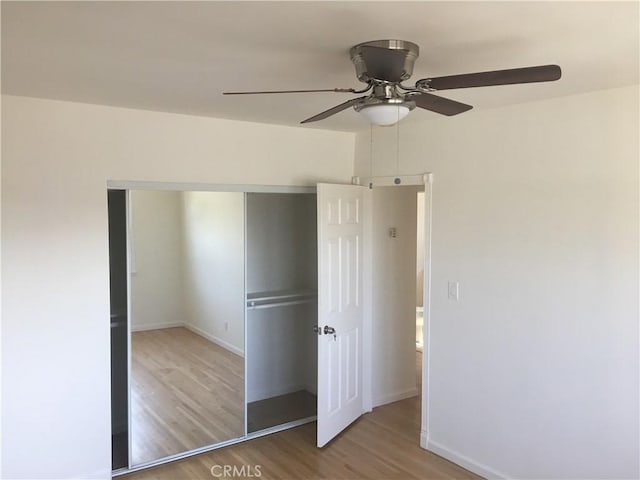 unfurnished bedroom with a closet, light hardwood / wood-style flooring, and ceiling fan