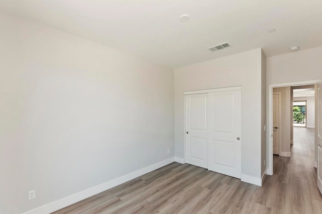 unfurnished bedroom featuring a closet and light hardwood / wood-style flooring