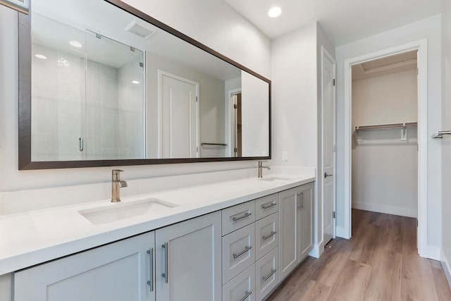 bathroom featuring hardwood / wood-style floors, vanity, and an enclosed shower