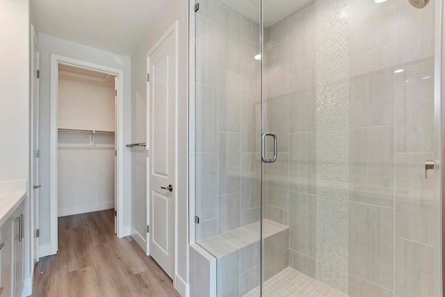 bathroom featuring wood-type flooring, vanity, and an enclosed shower