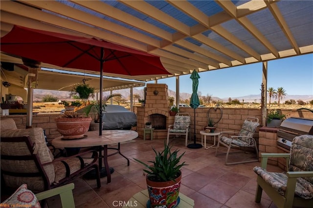 view of patio with an outdoor stone fireplace, grilling area, and a pergola