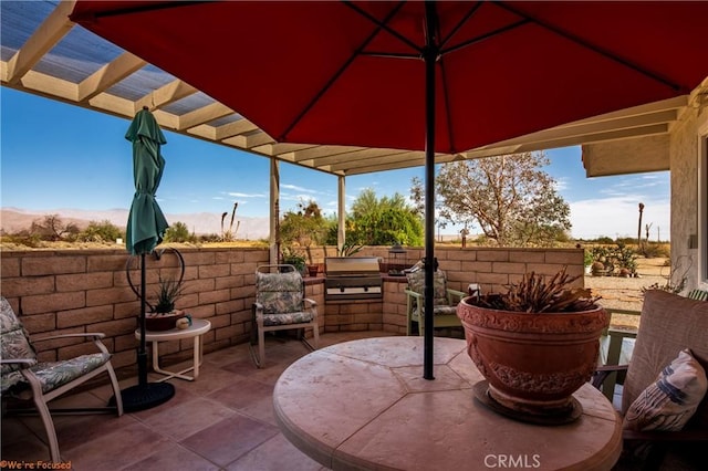 view of patio / terrace featuring exterior kitchen, area for grilling, and a pergola