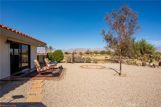 view of yard featuring a mountain view and a patio