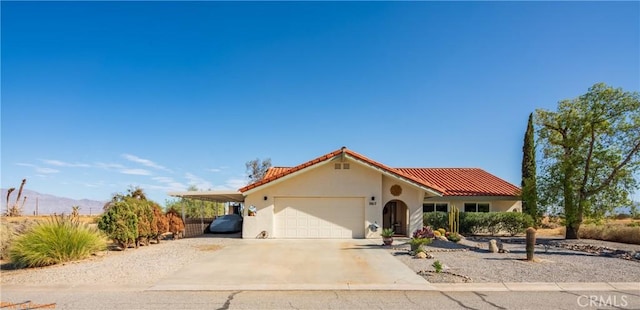 view of front facade featuring a mountain view, a garage, concrete driveway, a tiled roof, and stucco siding