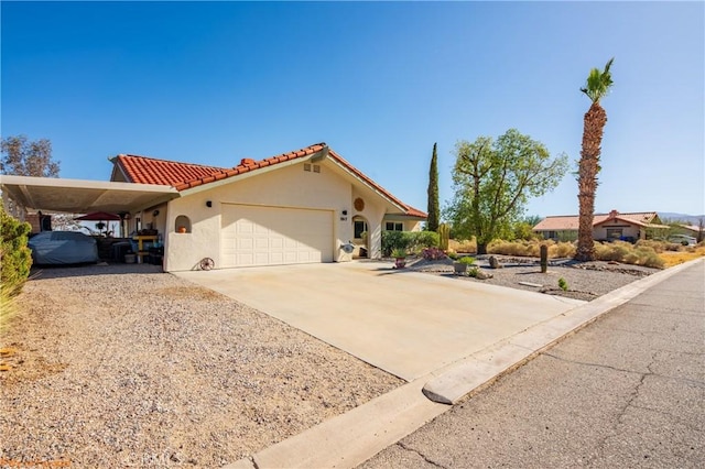 view of front of property featuring driveway, an attached garage, a tile roof, and stucco siding