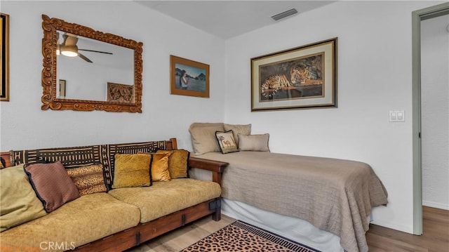 bedroom with wood finished floors, visible vents, and baseboards